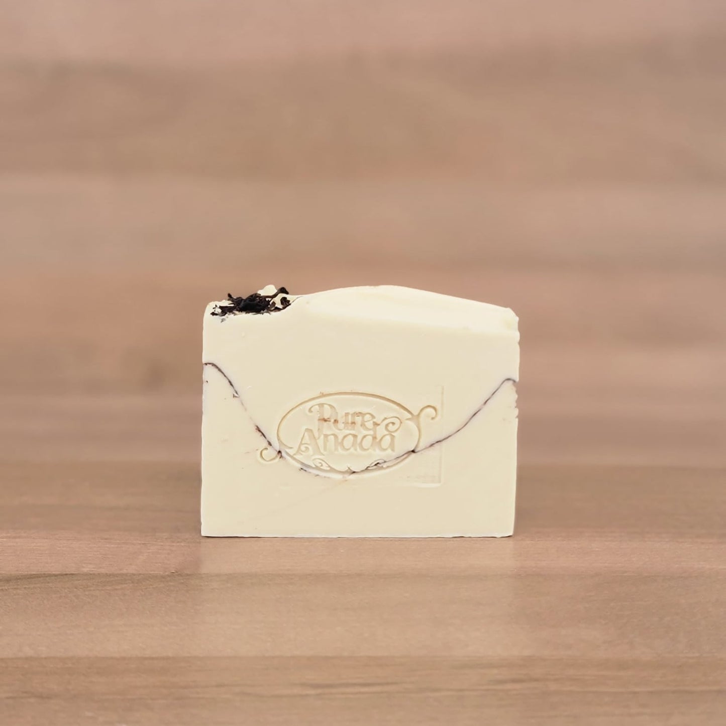 Bar of soap with a logo on a wooden surface