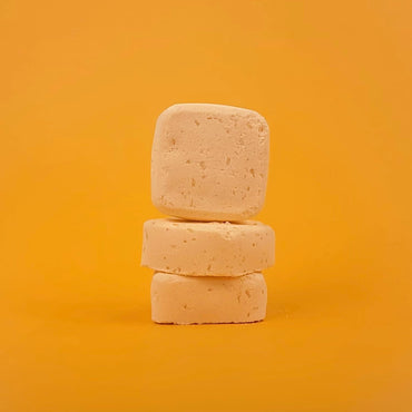 Three stacked soap bars on a yellow background