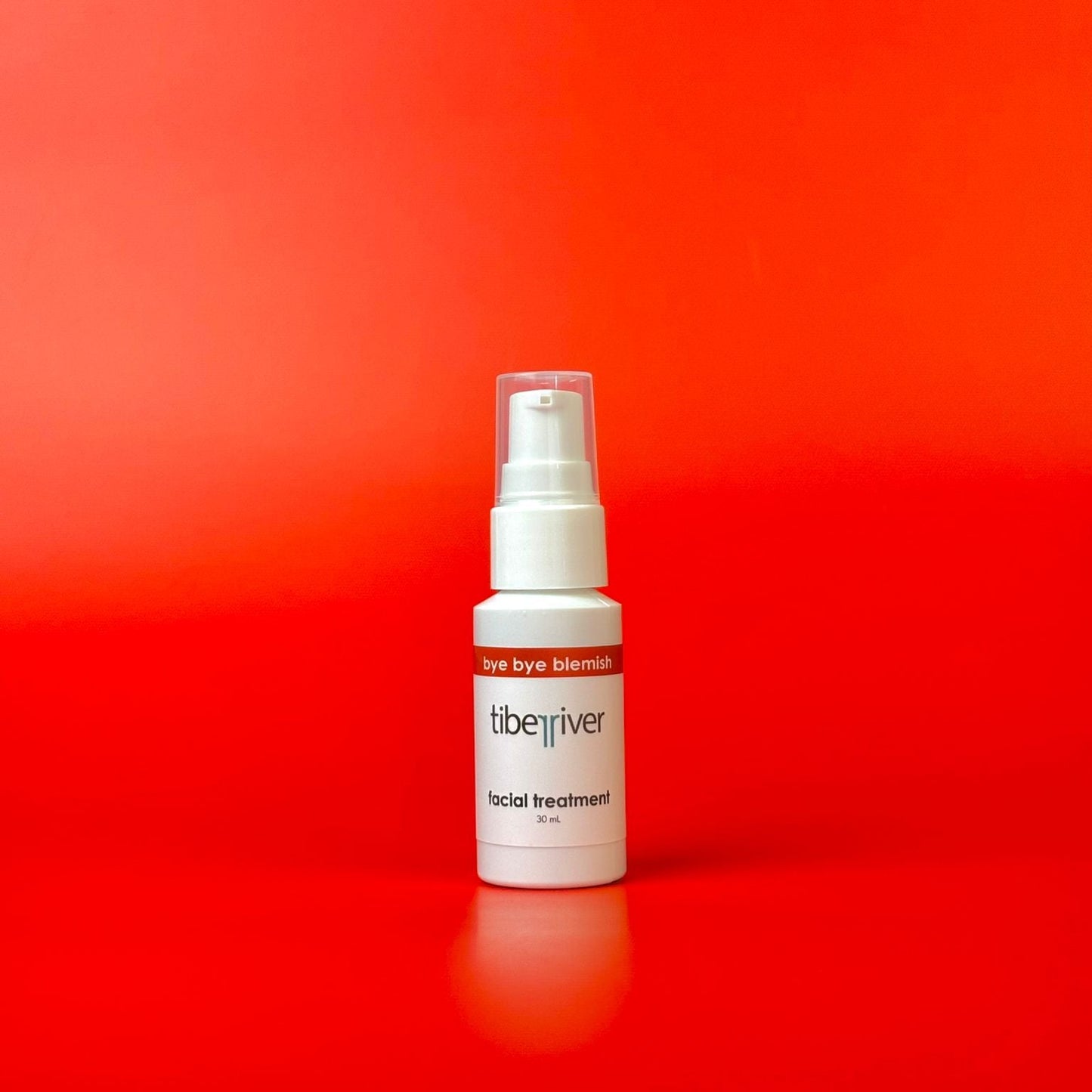 White spray bottle with red label on a red background