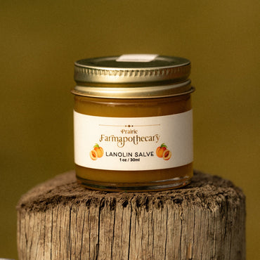 Jar of Lanolin Salve from Prairie Farmapotecary on a wooden block with a yellow background