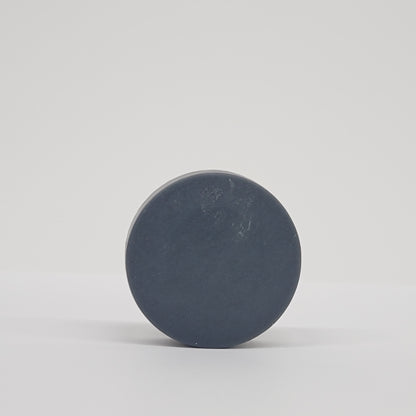 Round black puck soap on a white background
