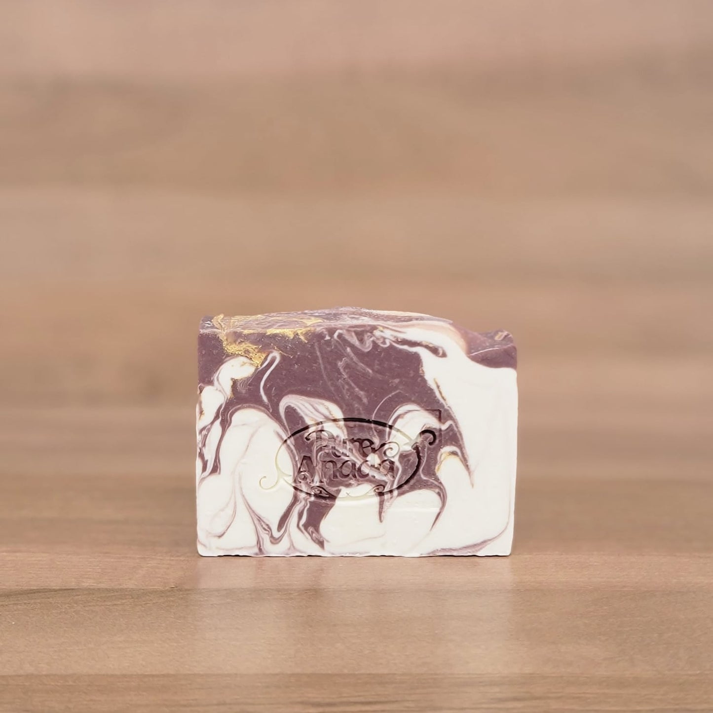 Marbled soap bar on a wooden surface with a blurred background