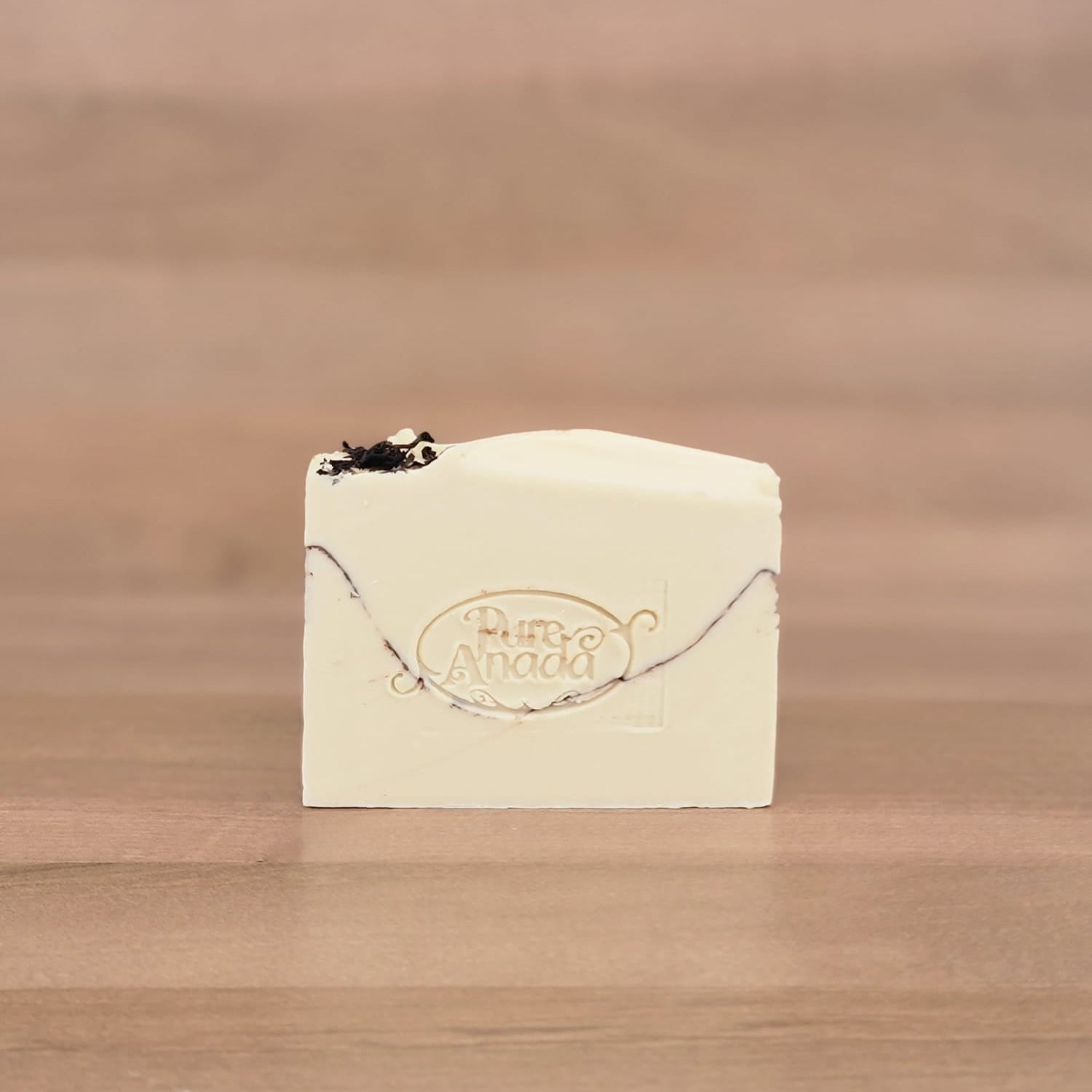 Bar of soap with a logo on a wooden surface