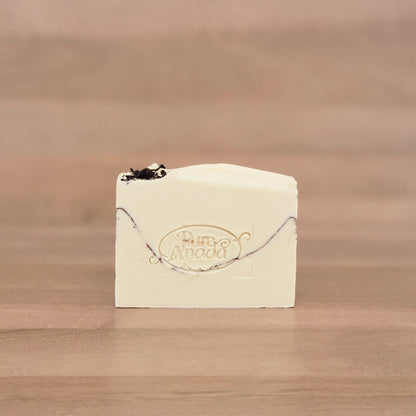 Bar of soap with a logo on a wooden surface