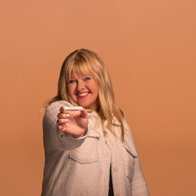 Woman holding a smartphone against an orange background