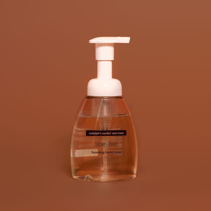 Foaming hand soap bottle with pump on a brown background
