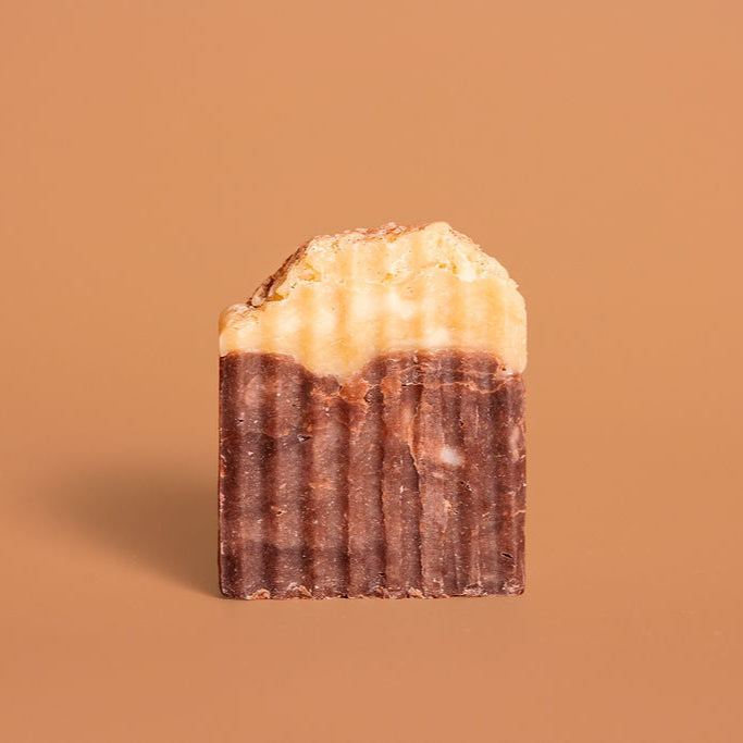 Chocolate bar with a cream topping on a brown background