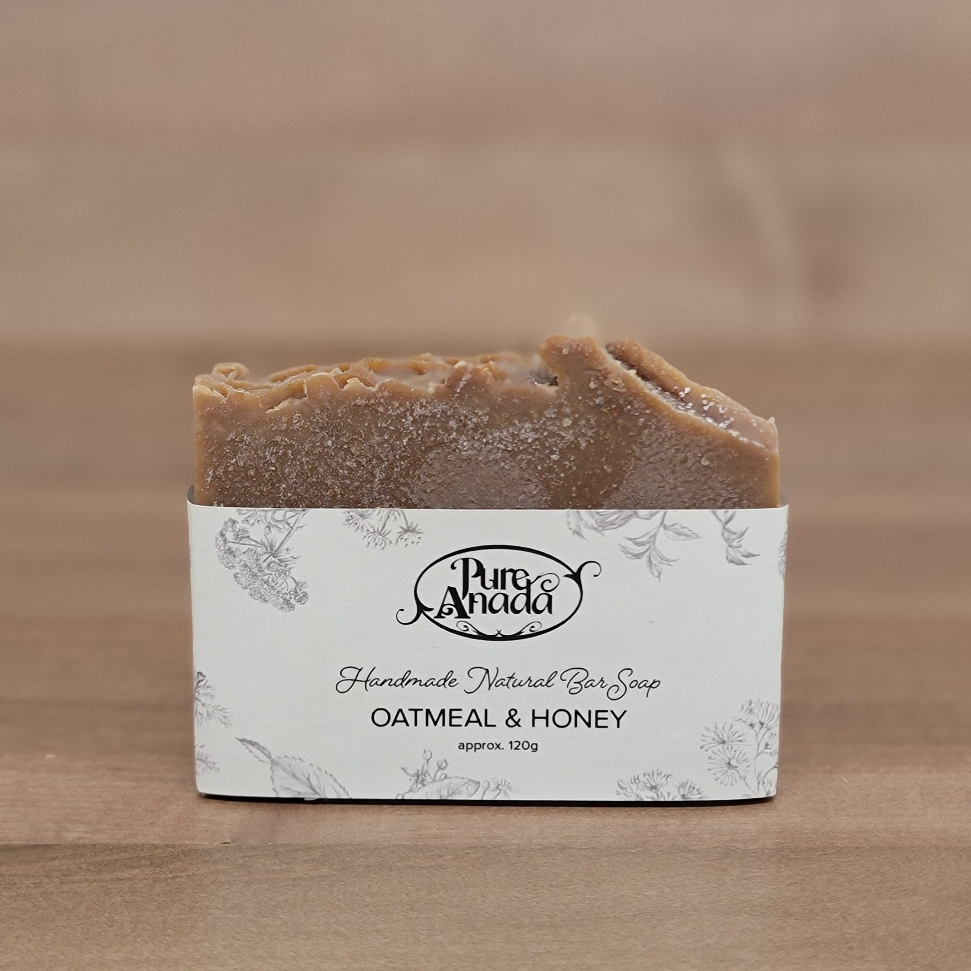 Bar of honeycomb and oat soap with a label on a wooden background