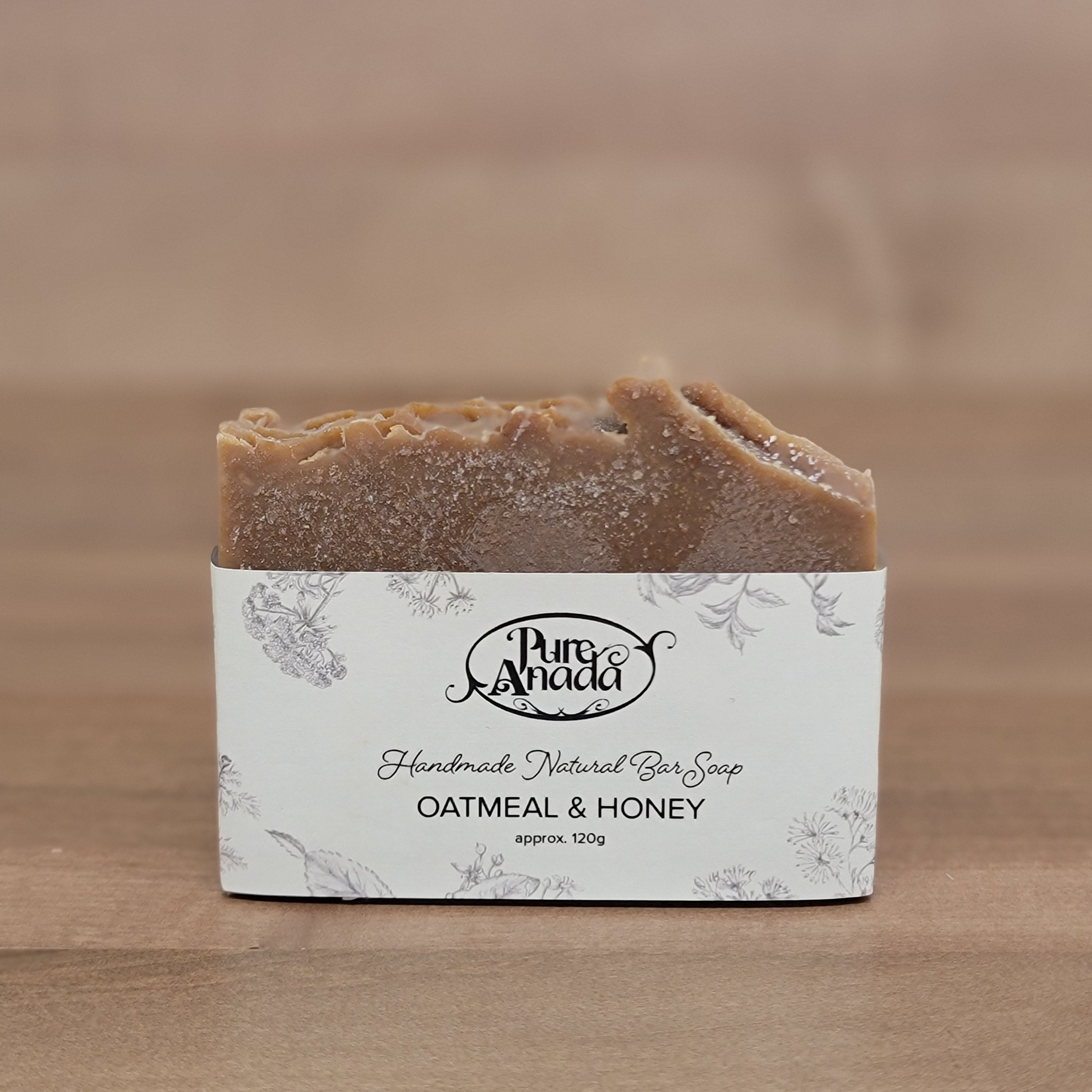 Bar of honeycomb and oat soap with a label on a wooden background