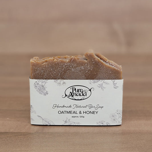 Bar of honeycomb and oat soap with a label on a wooden background