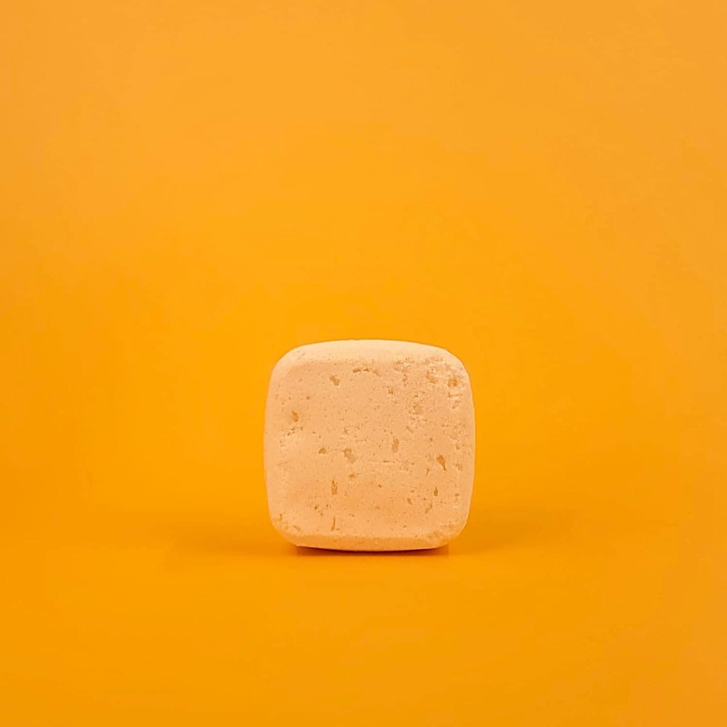 Square bar of soap on a gradient orange background