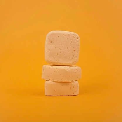 Three stacked soap bars on a yellow background