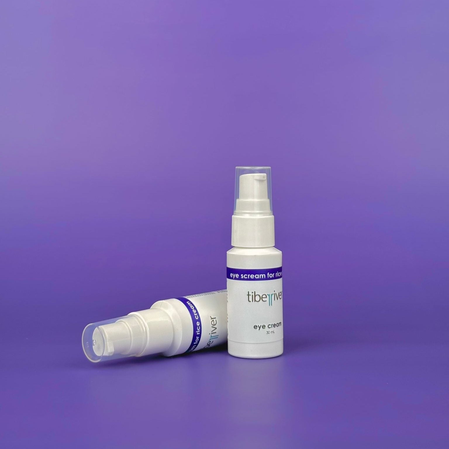Two white spray bottles with 'tiberius' branding on a purple background