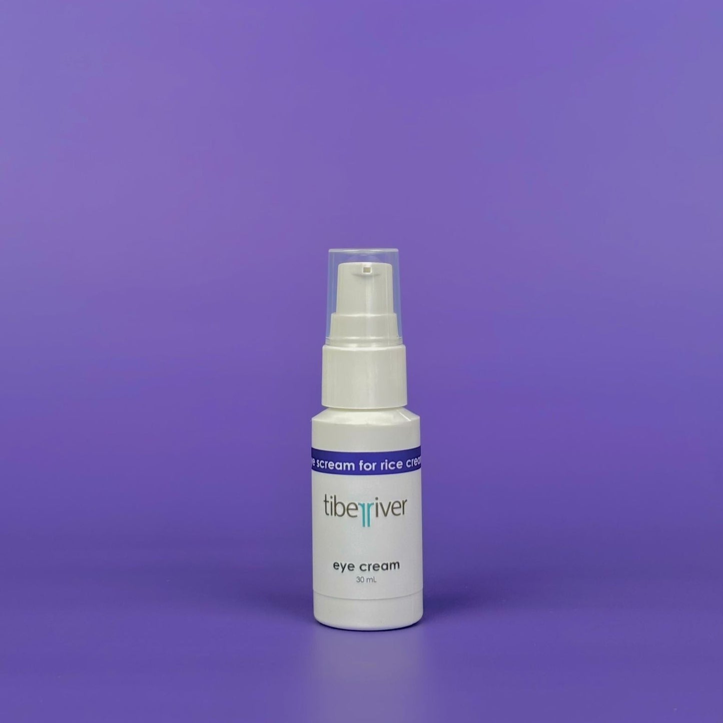 White bottle of eye cream with a blue label on a purple background