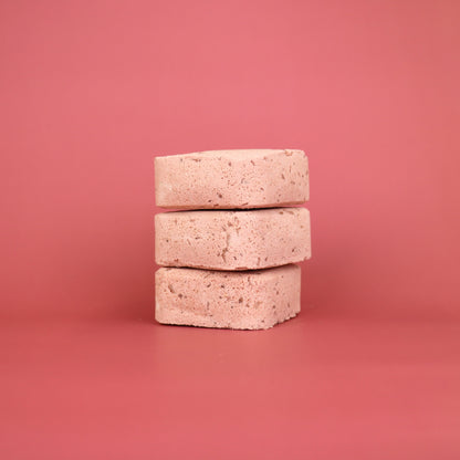 Stack of three beige stones on a pink background