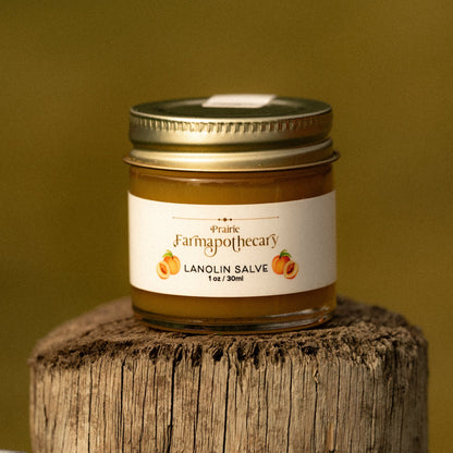 Jar of Lanolin Salve from Prairie Farmapotecary on a wooden block with a yellow background