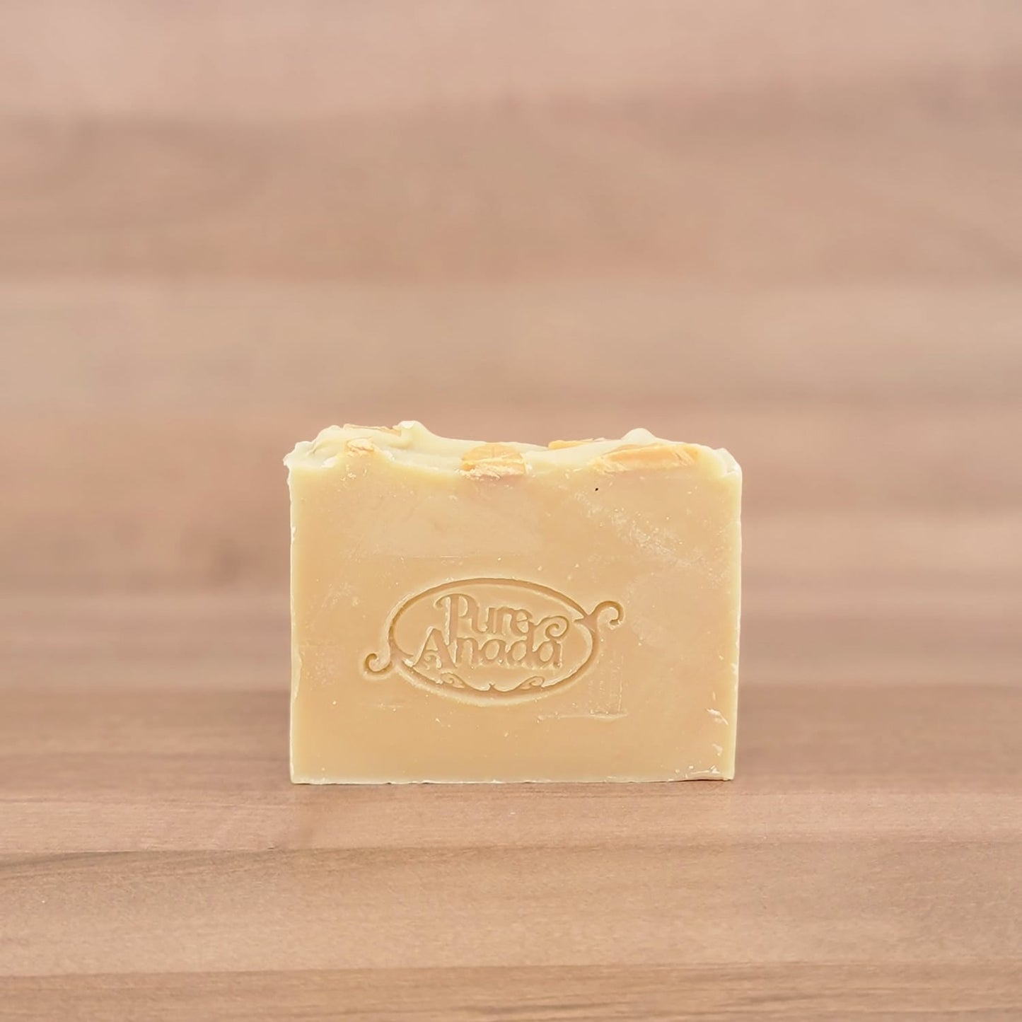 Bar of soap with a brand logo on a wooden surface